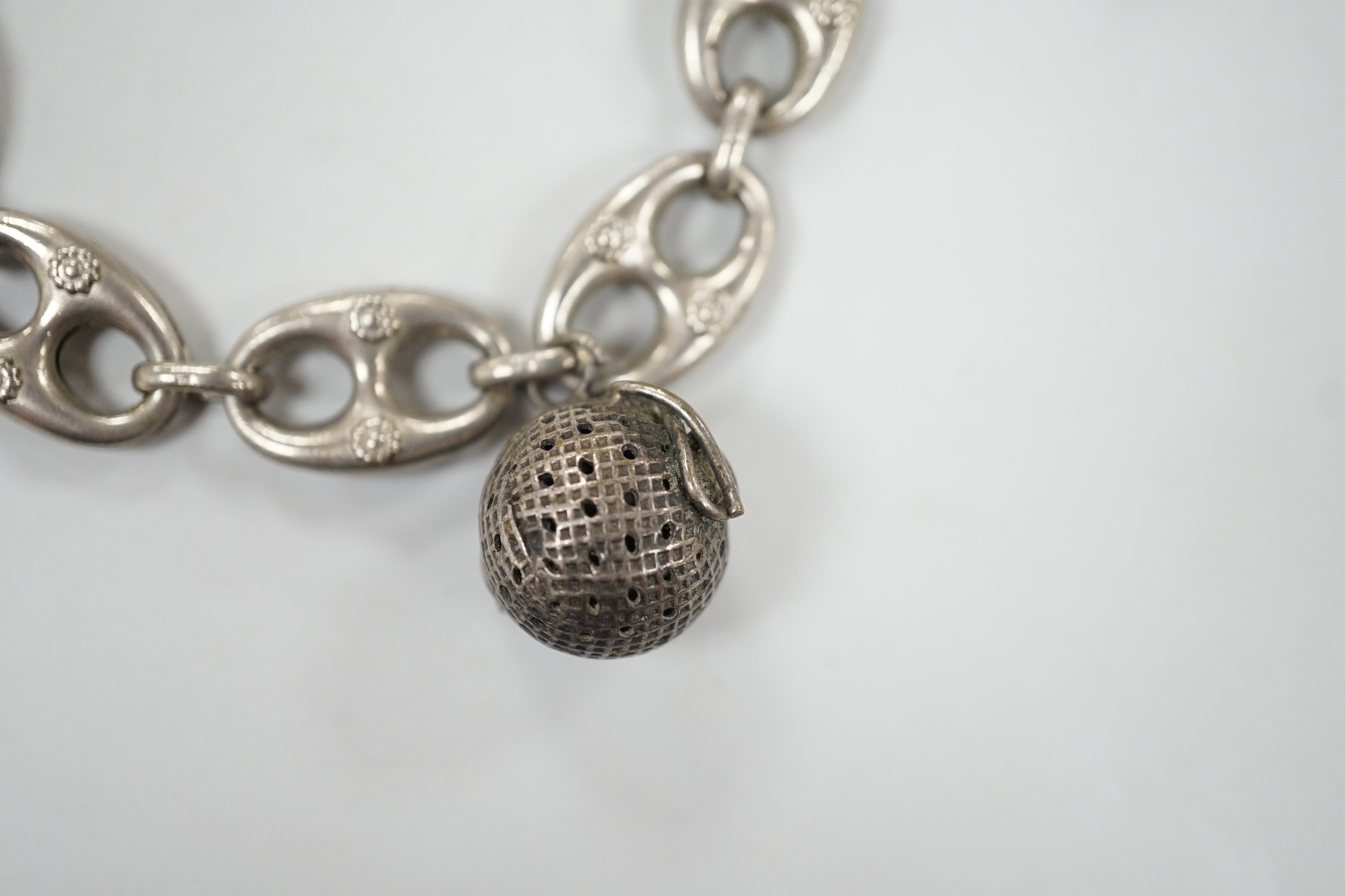 A white metal oval link bracelet, hung with three charms, including two fob seals, 21cm.
